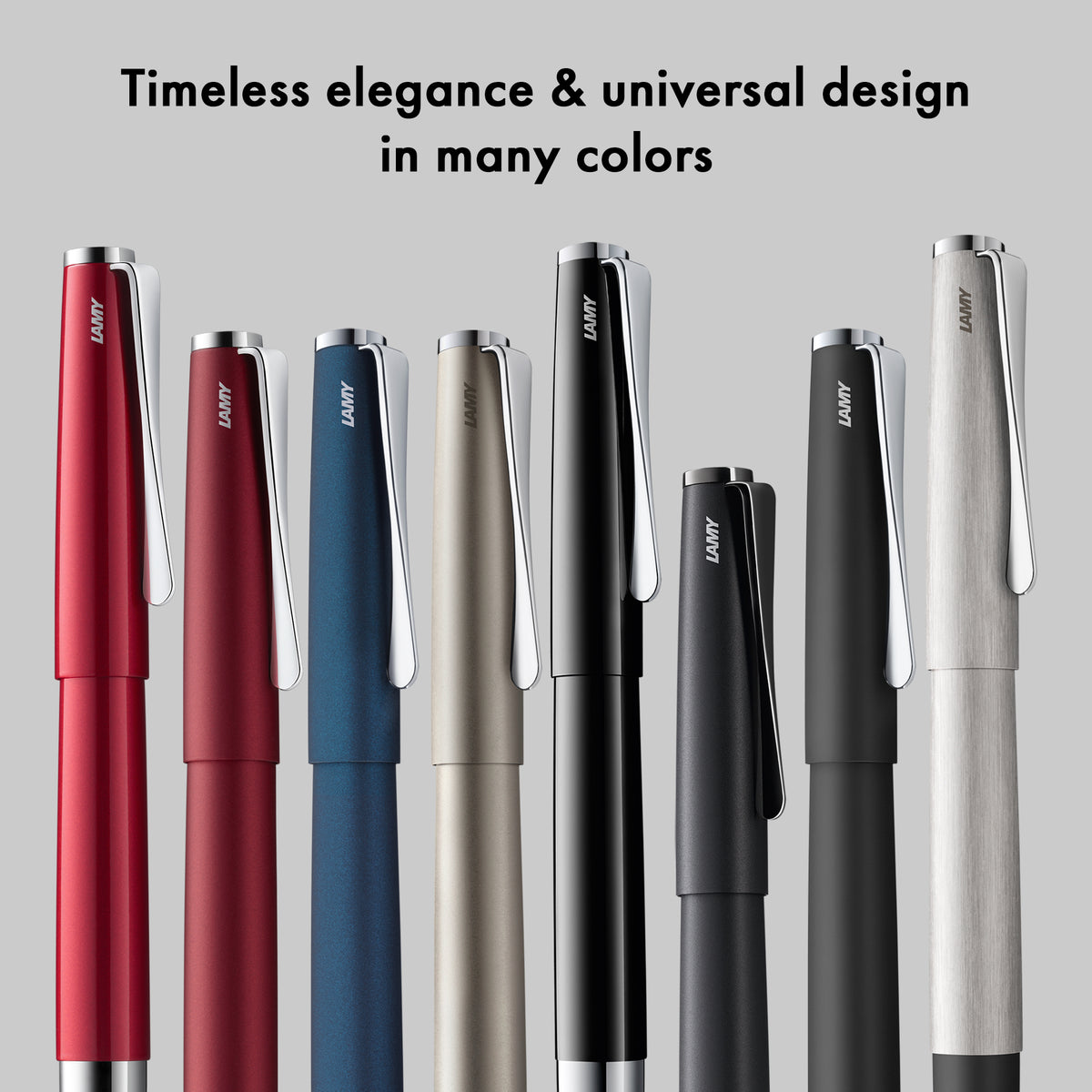 Set of pens in various colors with the brand name 'Lamy' on a gray background.