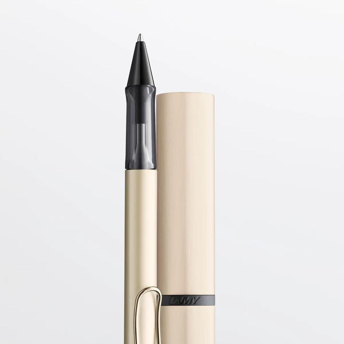 Pen with beige body and black cap on a light gray background