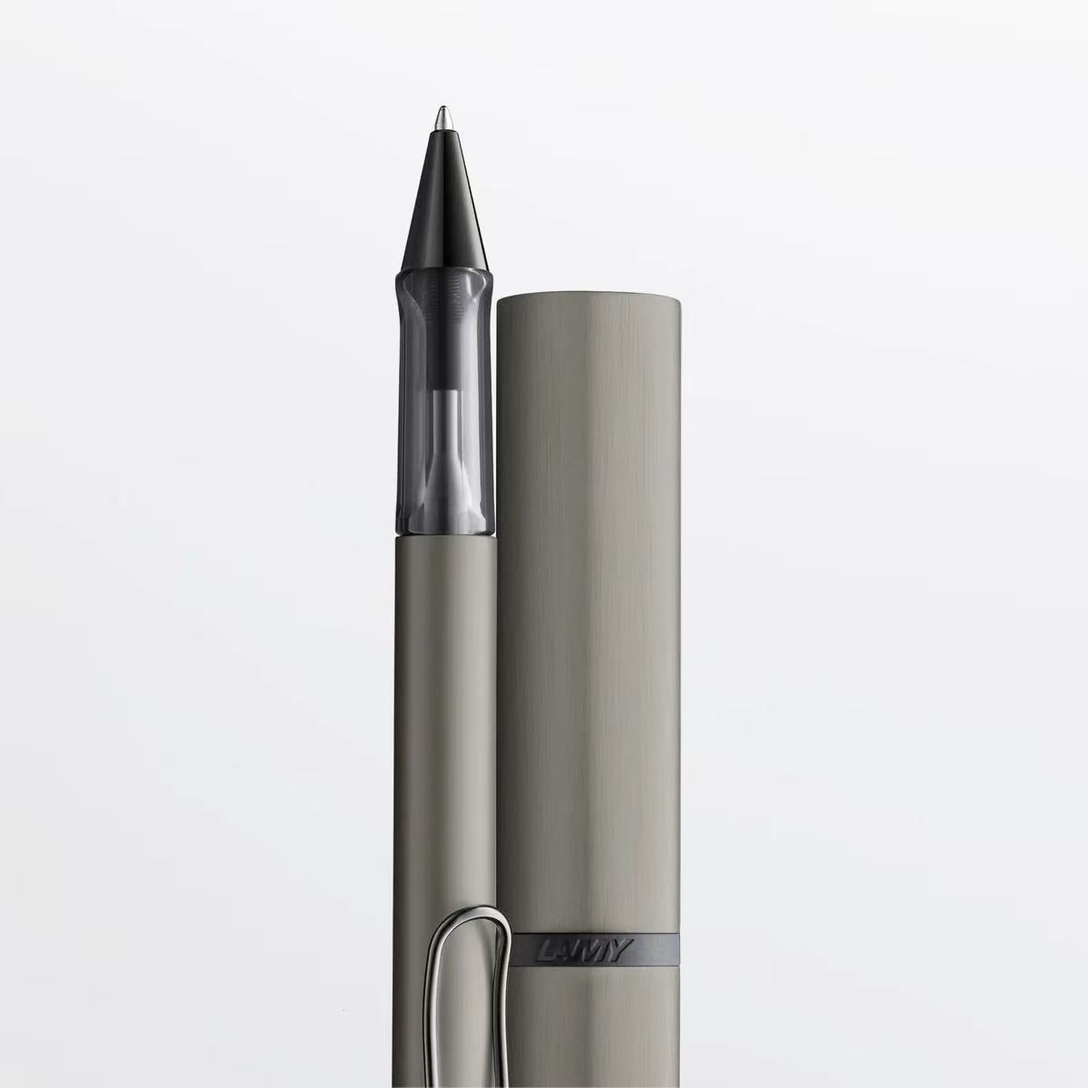 Metallic pen with cap on a light gray background