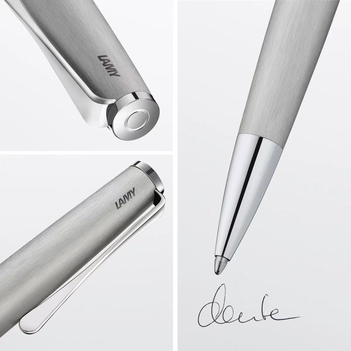 LAMY studio brushed steel ballpoint pen with a signature on a light gray background
