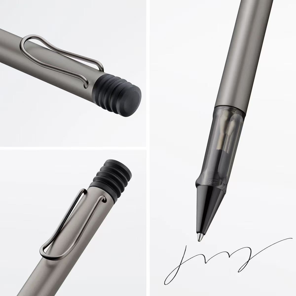 Close-up of a metallic pen with a signature on a light gray background